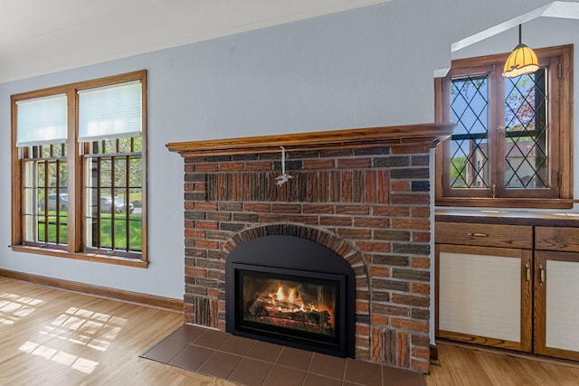 detailed view of wood finished floors, baseboards, and a fireplace