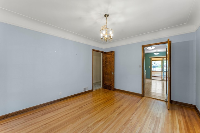 unfurnished room featuring a chandelier, light wood-style flooring, and baseboards