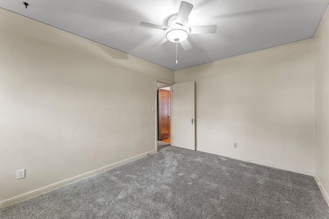 carpeted empty room featuring a ceiling fan and baseboards