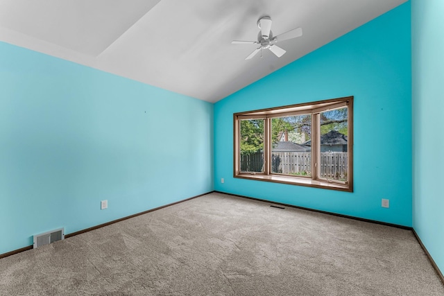 spare room with vaulted ceiling, carpet, ceiling fan, and baseboards