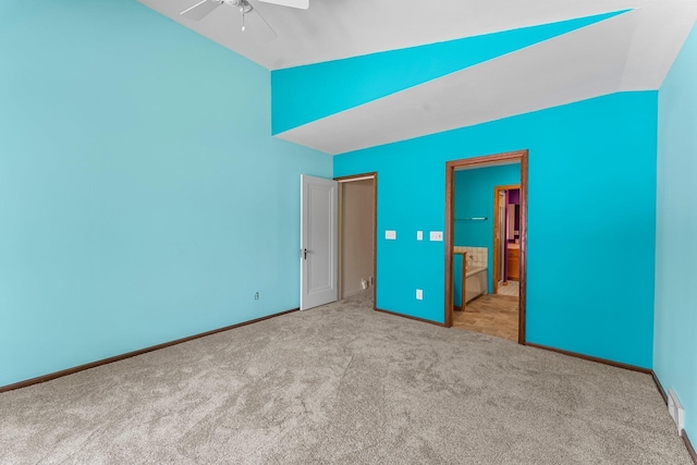 unfurnished bedroom with carpet, vaulted ceiling, baseboards, and ensuite bathroom