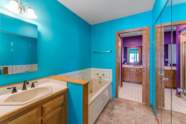 full bath with vanity and a jetted tub