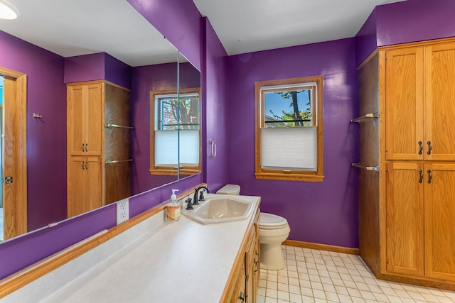 bathroom with toilet, baseboards, and vanity