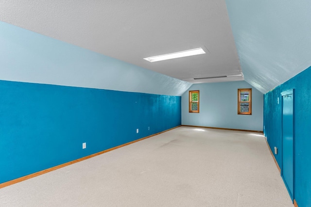 additional living space with lofted ceiling, baseboards, and carpet flooring