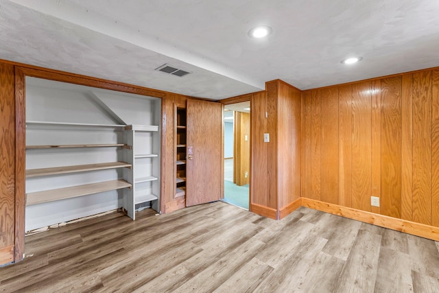 empty room with wood finished floors, stairs, and recessed lighting