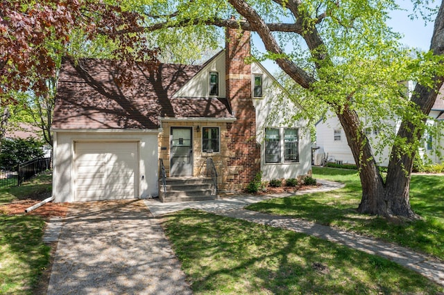 tudor-style house featuring concrete driveway, a garage, a chimney, and stucco siding