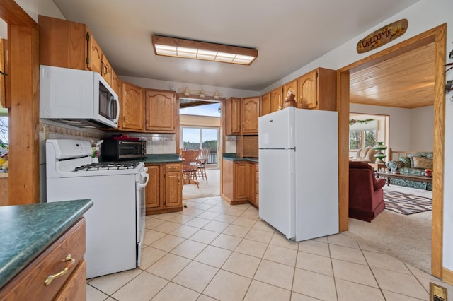 16227 Bay Dr, Pengilly, MN 55775 - kitchen with white appliances, healthy amount of natural light, dark countertops, and brown cabinets