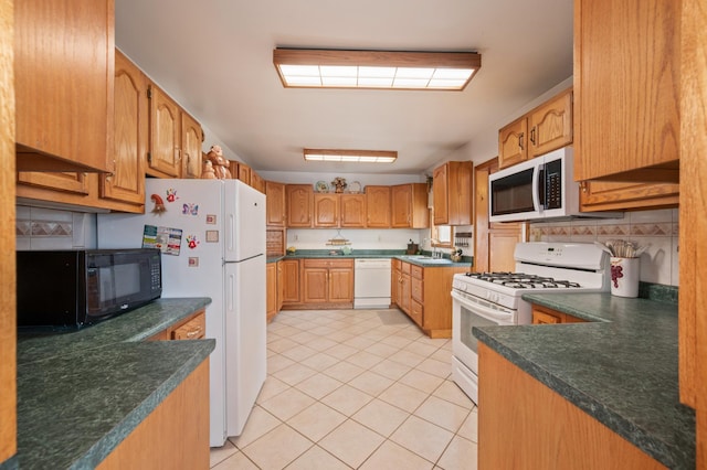 16227 Bay Dr, Pengilly, MN 55775 - kitchen featuring white appliances, light tile patterned floors, dark countertops, a sink, and backsplash