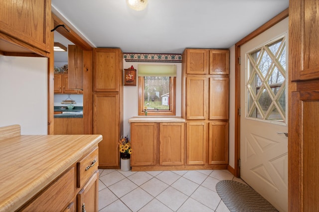 16227 Bay Dr, Pengilly, MN 55775 - kitchen with brown cabinetry, plenty of natural light, light tile patterned flooring, and light countertops
