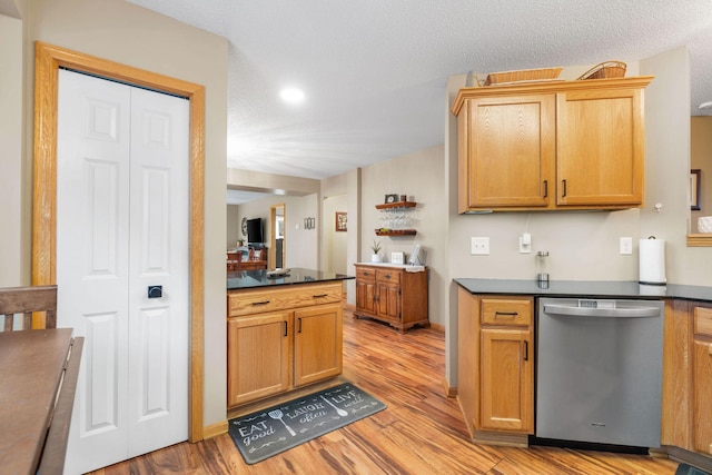 kitchen with stainless steel dishwasher, recessed lighting, light wood finished floors, and dark countertops