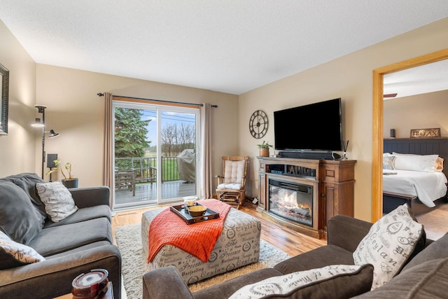 living room featuring a glass covered fireplace and wood finished floors