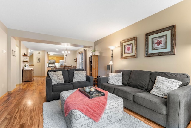 living room with an inviting chandelier and light wood-type flooring
