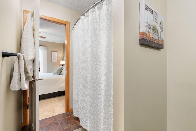 bathroom with a textured ceiling, ensuite bath, and a shower with curtain