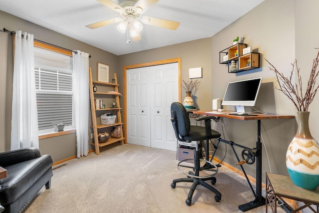 carpeted home office with baseboards, ceiling fan, and visible vents