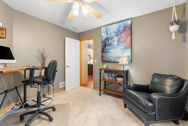 office area with carpet floors, a ceiling fan, baseboards, and visible vents