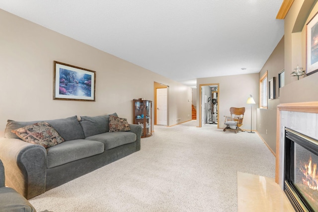 living area with baseboards, a high end fireplace, and carpet