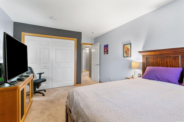 bedroom featuring light colored carpet and a closet