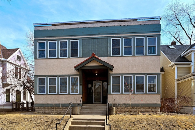 view of front facade featuring stucco siding and fence