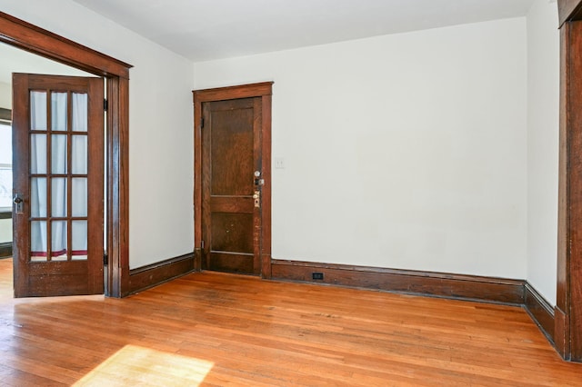 unfurnished room with light wood-type flooring and baseboards