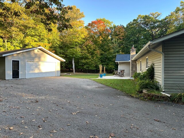 exterior space featuring an outdoor structure, a chimney, and a garage
