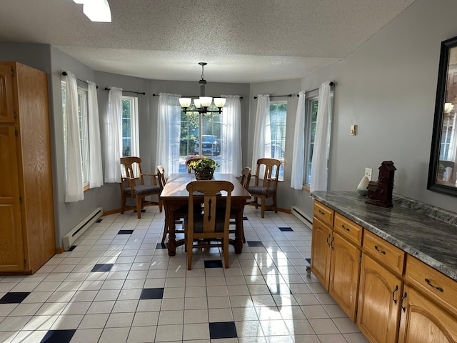 dining room featuring a baseboard heating unit, baseboards, a textured ceiling, and a notable chandelier