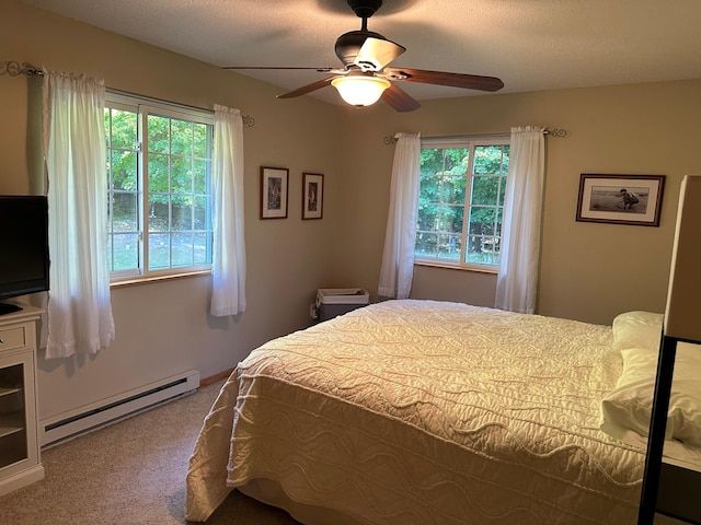 carpeted bedroom featuring a baseboard radiator and a ceiling fan