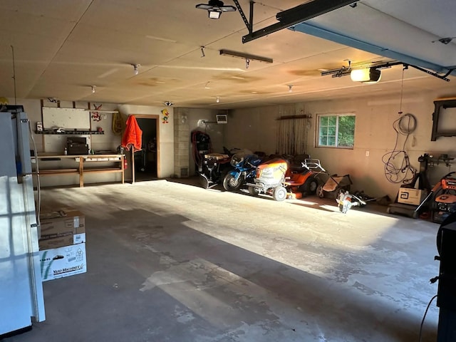 garage featuring freestanding refrigerator and a garage door opener