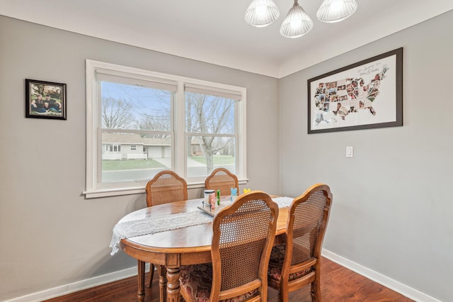 dining space featuring dark wood finished floors and baseboards