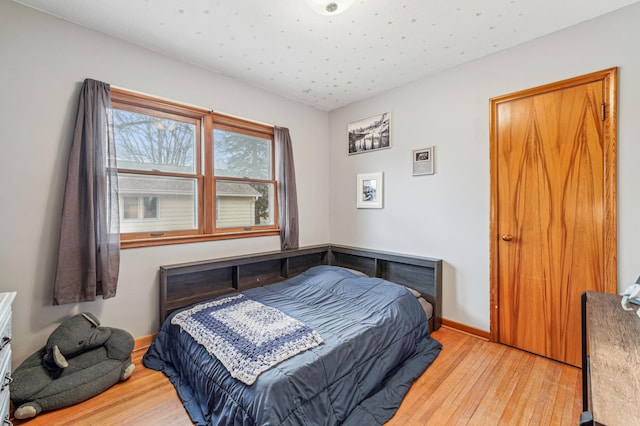 bedroom with hardwood / wood-style flooring and baseboards