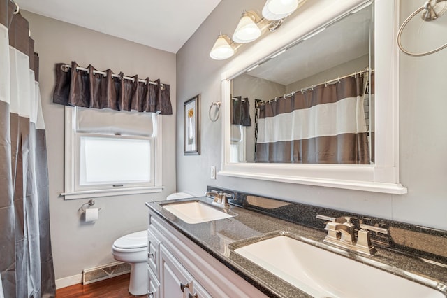 bathroom with toilet, wood finished floors, a sink, and visible vents