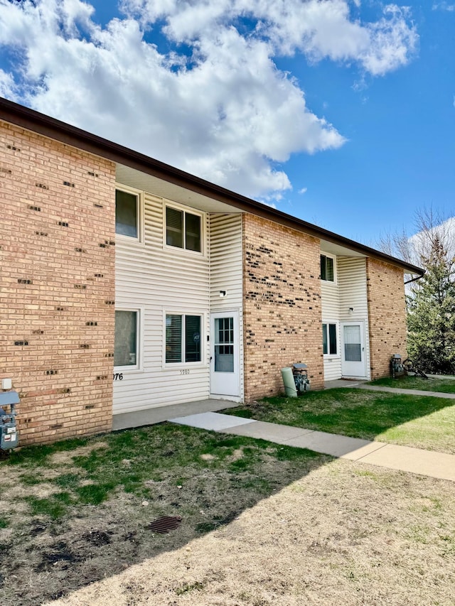 rear view of house featuring brick siding
