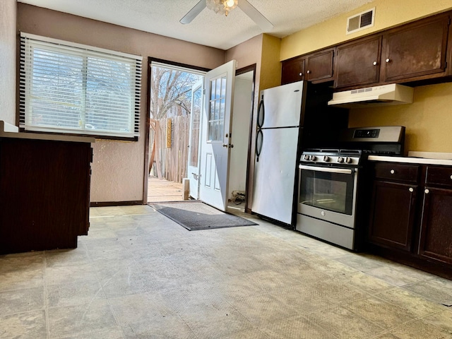 kitchen with appliances with stainless steel finishes, under cabinet range hood, dark brown cabinetry, a textured ceiling, and a ceiling fan
