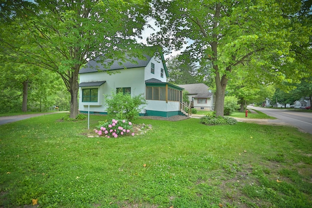 W340 State Road 29, Spring Valley, WI 54767 - view of home's exterior featuring a lawn, stucco siding, roof with shingles, and a sunroom