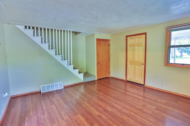 W340 State Road 29, Spring Valley, WI 54767 - unfurnished living room with a textured ceiling, wood finished floors, and stairway