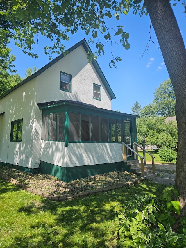 W340 State Road 29, Spring Valley, WI 54767 - rear view of property featuring a sunroom, stucco siding, entry steps, and a lawn