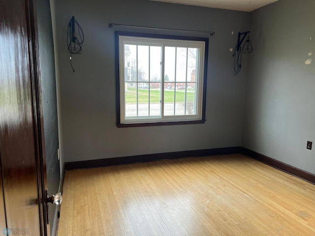 empty room with baseboards and wood finished floors