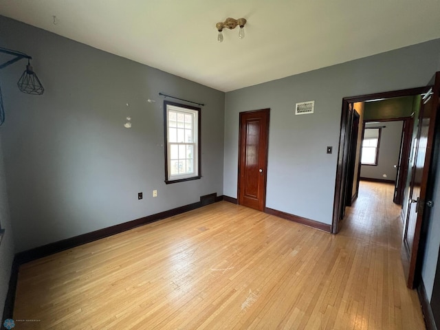 interior space featuring visible vents, light wood-style flooring, and baseboards