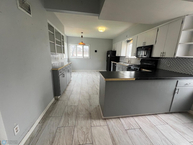 kitchen featuring visible vents, open shelves, decorative backsplash, a sink, and black appliances