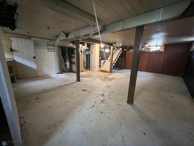 below grade area featuring stairs and heating unit