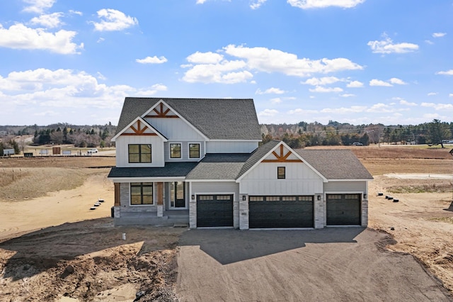 modern farmhouse style home featuring an attached garage, a shingled roof, dirt driveway, and board and batten siding