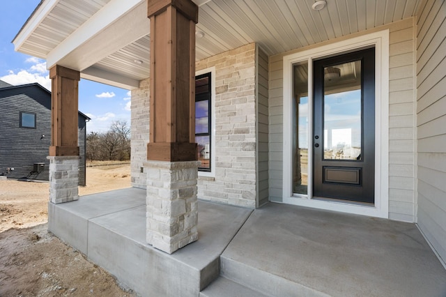 entrance to property with stone siding and covered porch