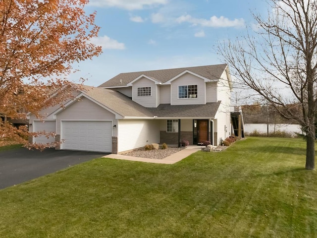 traditional-style house with roof with shingles, an attached garage, aphalt driveway, a porch, and a front yard
