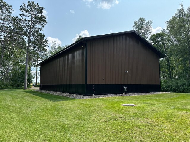 view of side of property with a lawn and an outdoor structure