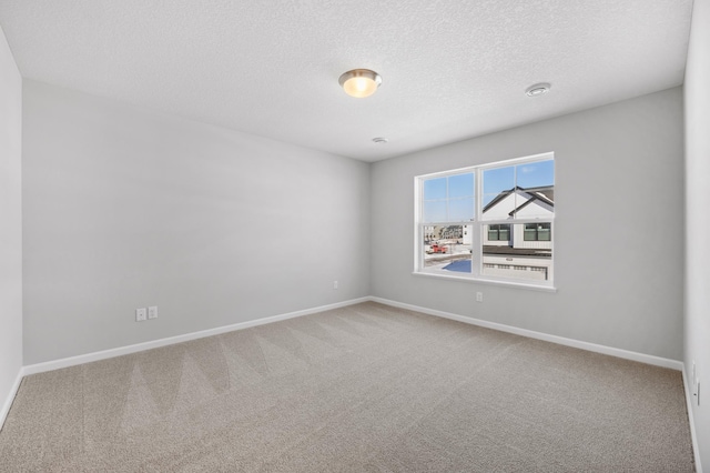 empty room with baseboards, a textured ceiling, and carpet