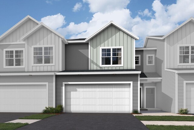 multi unit property with board and batten siding, an attached garage, and aphalt driveway