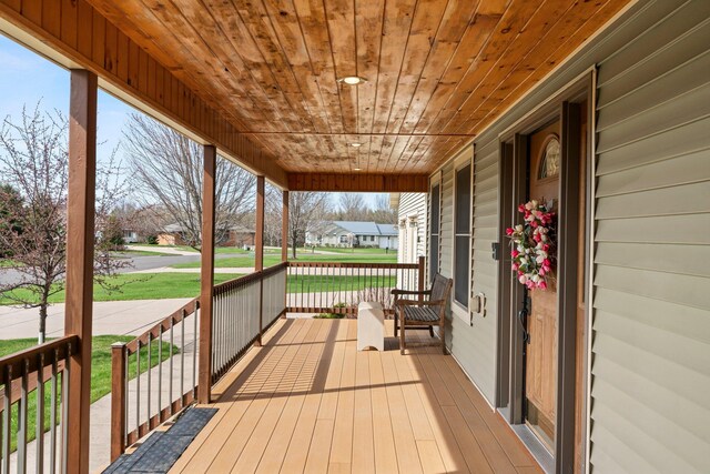 wooden deck with covered porch and a residential view
