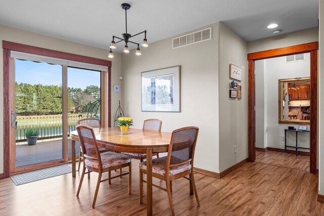 dining area with baseboards, visible vents, and light wood-style floors