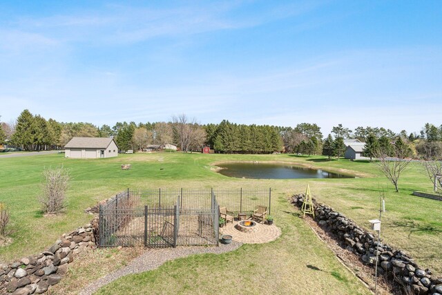 view of yard featuring a water view, fence, and a vegetable garden