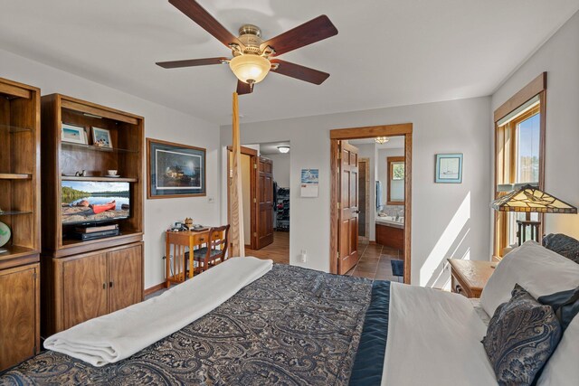 bedroom featuring baseboards, a ceiling fan, ensuite bath, and tile patterned floors