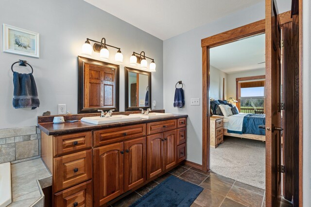 bathroom with connected bathroom, stone tile floors, a sink, and double vanity